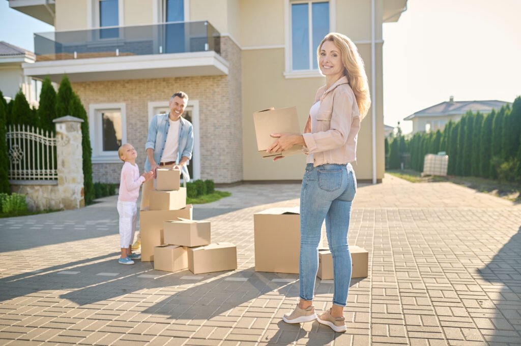 family moving to a new house and carrying cardboard boxes