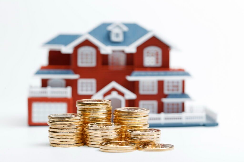 rmb coins stacked in front of the housing model (house prices, house buying, real estate, mortgage concept) rmb coins stacked in front of the housing model (house prices, house buying, real estate, mortgage concept)